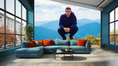 guy sits on top of the mountain Wall mural