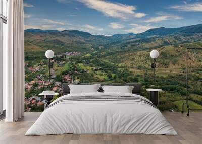 Aerial view in a rural area on a village in Romania with mountains and hill at sunset Wall mural