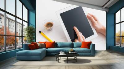 Hands of a man holding blank tablet device over wooden table Wall mural