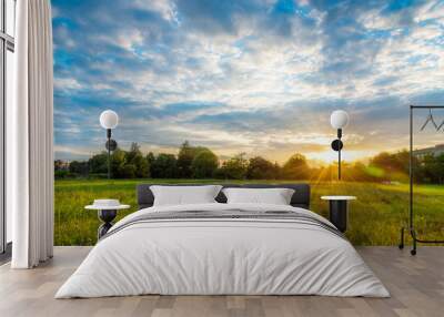 Beautiful sunset landscape over a meadow in evening - colorful sunlight wallpaper Wall mural