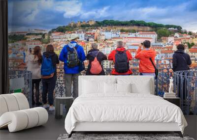 group of tourists watching the cityscape of lisbon and taking pictures to sao jorge castle in portug Wall mural