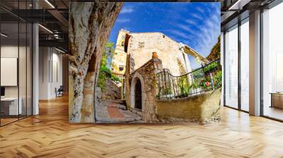 Old traditional architecture of Eze village, historic tower of church and the main entrance gate of the town in France Wall mural