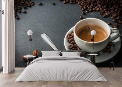 A cup of coffee on blue stone table with a spoon, cinnamon sticks and some fresh roasted coffee beans Wall mural