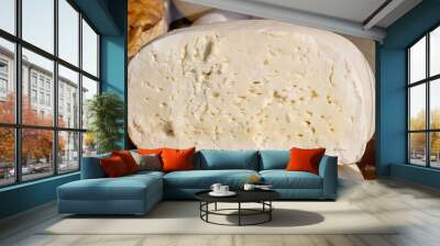 A piece of home made cheese from cow and sheep milk, known as telemea, displayed for sale at a street food market, side view of healthy food photographed with soft focus Wall mural