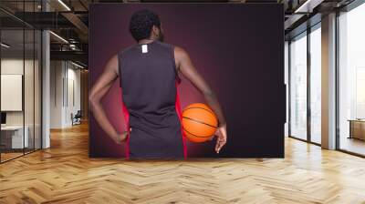 Back view of afro american basketball player holding a ball on d Wall mural