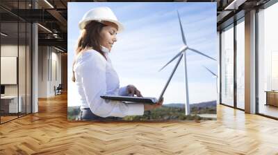 Environmental engineer with a laptop at wind farm Wall mural