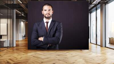 handsome businessman with crossed arms against dark background Wall mural