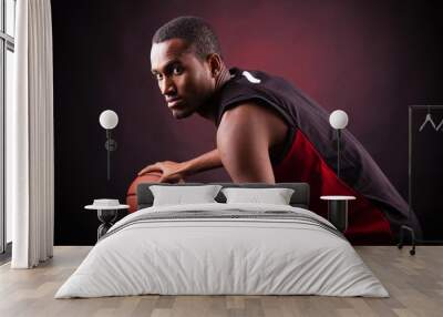 portrait of a young male basketball player against black backgr Wall mural