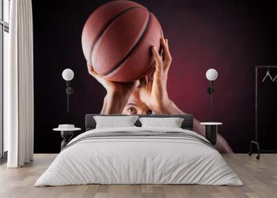 portrait of a young male basketball player against black backgr Wall mural