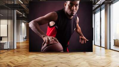 Portrait of a young male basketball player against black backgr Wall mural