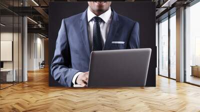 Smiling business black man whit laptop on black background Wall mural