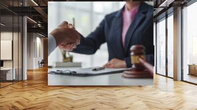 Lawyer shaking hands with client after agreement on business contract hammer of justice Customers shake hands after instructions in the office Legal service concept. Wall mural