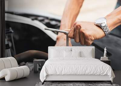 The male mechanic's hand holds the wrench In order to fix And check car engine, engineer concept and car repair Wall mural