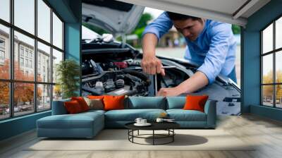 The male mechanic's hand holds the wrench In order to fix And check car engine, engineer concept and car repair Wall mural