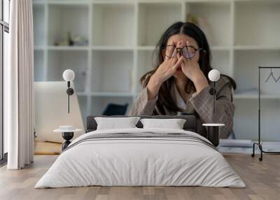 tired business woman sleepy and bored from sitting at a desk for a long time and has office syndrome Wall mural