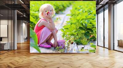 Young children picking strawberries in the farm. Small toddler girl harvesting healthy berries in the garden. Healthy bio food concept. Wall mural