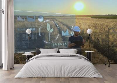 Smart precision farm industrial revolution concept, engineer work on a tablet analysing the graphics statistics of Harvester production in a wheat grain field during sunset Wall mural