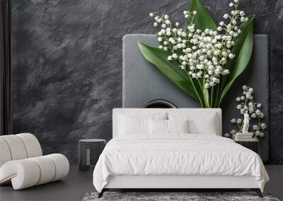 Flat lay of a coffee mug alongside a lily of the valley bouquet on a gray stone table embodying a minimalistic style for a beautiful morning breakfast setup Wall mural