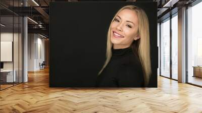 Beautiful portrait of smiling blond woman on a black background Wall mural