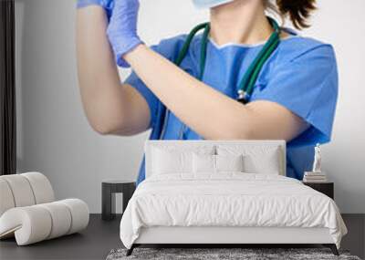 Doctor putting on blue surgical gloves Wall mural