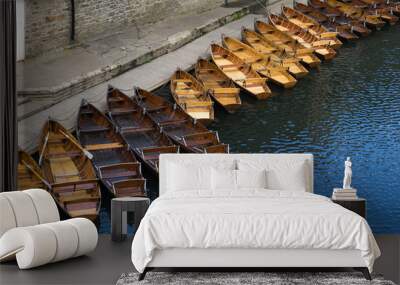 Small wooden boats moored at the edge of the Wear River as it passes through the city of Durham. Wall mural