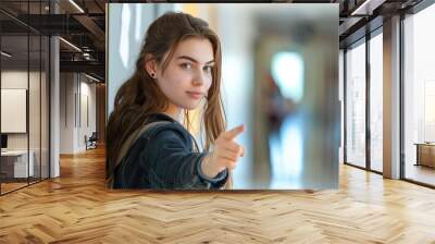 a beautiful female student pointing at a blank space at school  Wall mural