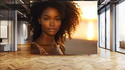 Close up portrait of young woman, black skin, looking at the camera at the beach with the sunset Wall mural