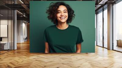 Portrait of funny young lady dressed casual t-shirt smiling on dark green background. Wall mural