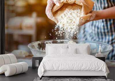 Bakery chef's hands pour the flour from the brown flour paper bag into a large, clear mixing bowl Wall mural