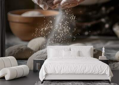 Bakery chef is sprinkling white flour by two hands from the top onto a smooth ball of dough on a table. Wall mural