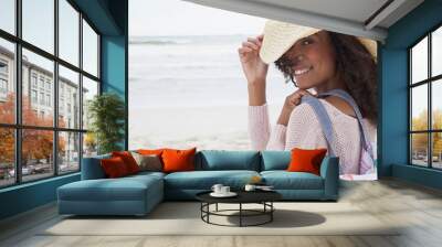 Young woman wearing hat on beach Wall mural