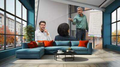 Businessman writing ideas on flip chart during meeting Wall mural