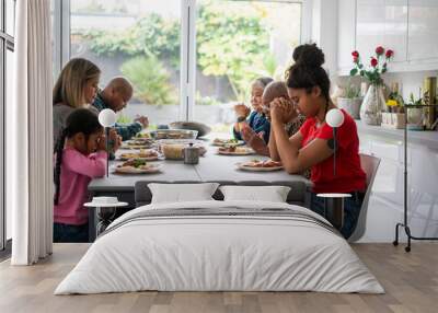 Family praying before eating dinner Wall mural