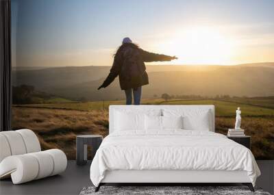 Female hiker walking in rural landscape Wall mural