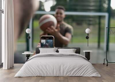 Man photographing friend with basketball ball Wall mural