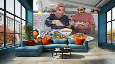 Mid adult couple eating meal at home Wall mural