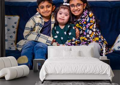 Portrait of siblings sitting on sofa Wall mural