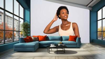 Studio portrait of smiling woman in cream colored tank top Wall mural