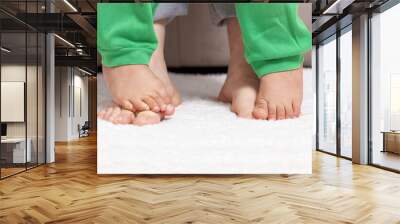 Cropped shot of a mother and her baby boy's feet together making the first steps of his life together Wall mural