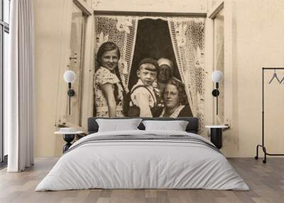 Latvia - CIRCA 1930s: A family sitting together in a window sill group shot. Children lived in a three generation family household. Vintage art deco era photo Wall mural