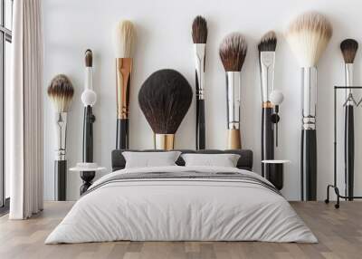 A row of makeup brushes are lined up on a white background Wall mural