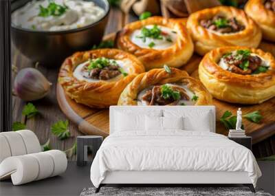 Flaky, golden pastry rings surround a savory blend of lamb, onions, and spices, served with a dollop of creamy tzatziki sauce. Wall mural