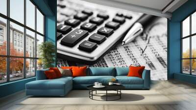 A calculator and pen on financial documents with charts and graphs. Wall mural