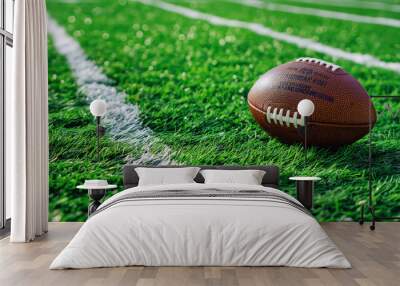 A football rests on the green field of a stadium, highlighting the sport's excitement and anticipation. Wall mural