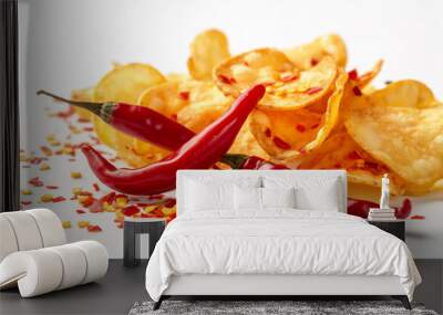 A pile of potato chips with chili peppers and crushed red pepper flakes scattered across a white background.

 Wall mural