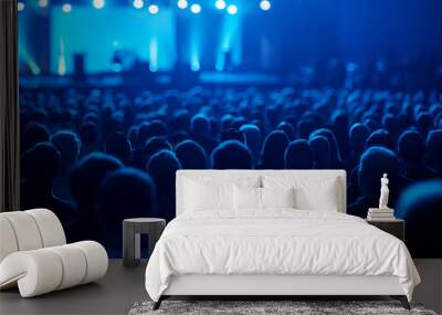 Audience attending a conference with blue lighting and large screens. Wall mural