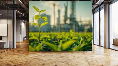 Green plants growing near an industrial plant with mountains in the background. Wall mural