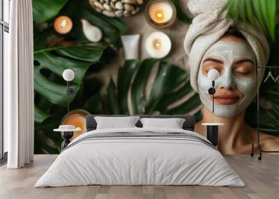 Woman relaxing with facial mask and candles surrounded by green leaves in spa setting. Wall mural