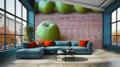 Green apples stand on a wooden surface Wall mural