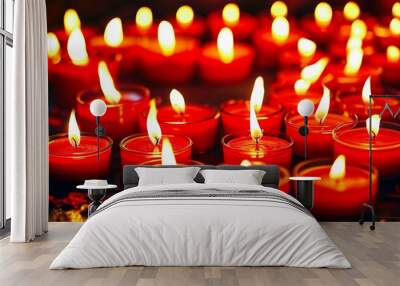 Glowing red candles cast warm, flickering light on a dark background, creating a romantic and intimate atmosphere Wall mural